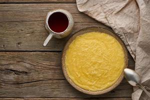 polenta di porridge con tazza di tè, fondo in legno scuro, spazio per la copia vista dall'alto foto