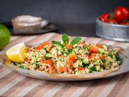 insalata di tabbouleh con quinoa. cibo orientale con mix di verdure, dieta vegana. vista laterale foto