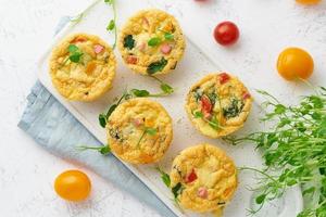 frittata con pomodori e pancetta, uova al forno con spinaci e broccoli, vista dall'alto, cheto, chetogenica foto