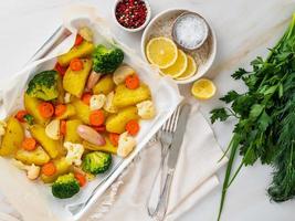 verdure arrosto su vassoio con pergamena su tavola di marmo. patate, carote,