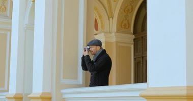 il giovane viaggiatore maschio bello con la cinepresa fa foto di strada