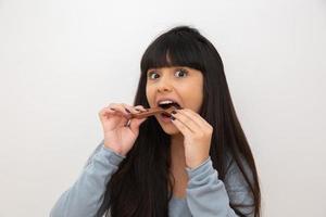 giovane donna che mangia cioccolato foto