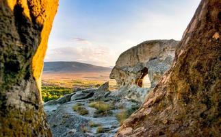 vista panoramica grandangolare alle strutture della città della caverna di uplistsikhe con lo sfondo del paesaggio della natura del tramonto foto