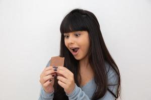 giovane donna che mangia cioccolato foto