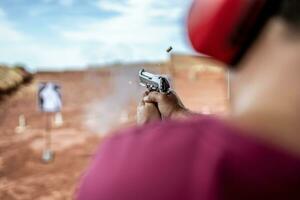 vista dettagliata del tiratore con pistola e tiro tattico di addestramento, focus sulla pistola. poligono di tiro. foto