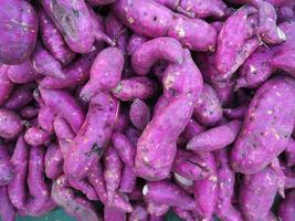 mucchio di patate dolci viola fresche organiche per la vendita nel mercato foto