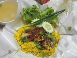 pollo biryani cibo, colore giallo tradizionale piatto indiano di riso e pollo marinato in spezie con salsa verde foto