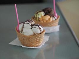 cioccolato, tè tailandese all'arancia, gelato al latte di cocco in una tazza di cialda croccante sul tavolo a specchio foto