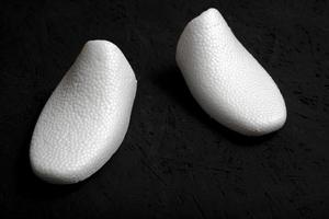 forma di scarpa in schiuma bianca su sfondo nero. foto