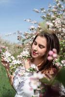 giovane donna caucasica godendo la fioritura di un melo foto