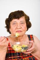 donna anziana che mangia insalata foto