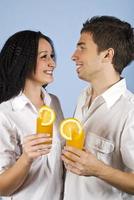 felice giovane coppia con succo d'arancia fresco foto