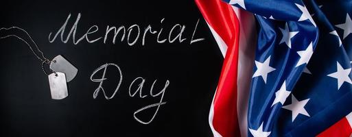 concetto di giorno della memoria degli Stati Uniti. bandiera americana e medagliette su sfondo nero. scritte a mano sulla lavagna. foto