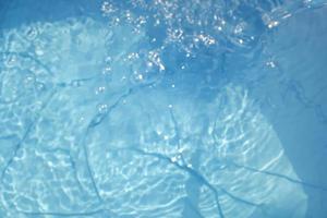 sfoca lo sfondo astratto della superficie dell'acqua blu, spruzzi d'acqua nel mare profondo. foto