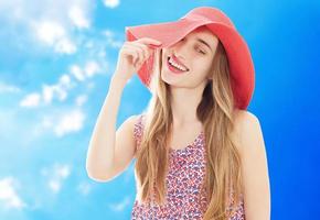 giovane bella donna bionda che indossa cappello estivo e vestito isolato su sfondo bianco preparando per le vacanze foto