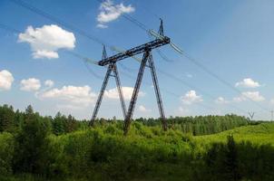 linee elettriche sulle pendici delle montagne sullo sfondo della foresta. foto