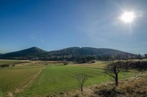 ampio paesaggio con montagne e sole foto