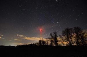 mulino a vento ad alberi e cielo stellato foto