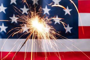 concetto per celebrare l'indipendenza o il giorno della memoria. sparkler su uno sfondo di bandiera americana. foto