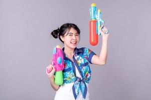 belle donne asiatiche tengono pistole ad acqua di plastica in un antico tempio durante il Songkran, il festival dell'acqua più bello e divertente della Thailandia foto