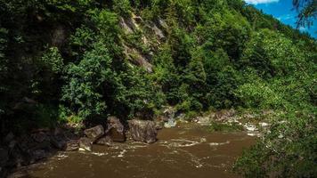 forte flusso e ebollizione dell'acqua nel fiume di montagna con schizzi. flusso veloce nei carpazi, ucraina. pietre in un fiume di montagna. sfondo naturale dell'acqua. avvicinamento. foto