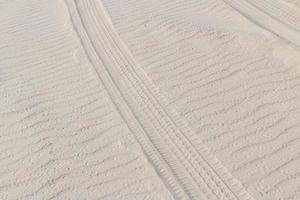 pista di pneumatici nella sabbia delle dune sulla spiaggia o nel deserto. foto