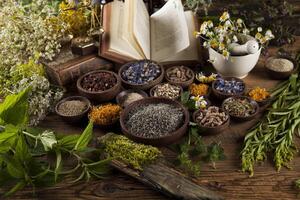 erboristeria e libro su sfondo tavolo in legno foto