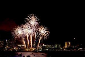 molti fuochi d'artificio lampeggianti con sfondo paesaggio urbano notturno festeggiano il nuovo anno. foto