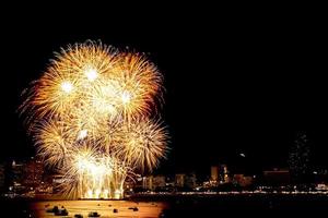 molti fuochi d'artificio lampeggianti con sfondo paesaggio urbano notturno festeggiano il nuovo anno. foto