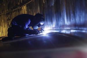 saldatura ad arco argon lavoratore maschio metallo riparato sta saldando scintille costruzione industriale serbatoio inossidabile foto