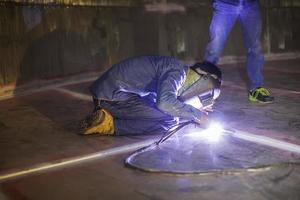 saldatura ad arco argon lavoratore maschio metallo riparato sta saldando scintille costruzione industriale serbatoio inossidabile foto