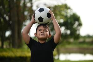 ragazzino mano che tiene calcio calcio foto