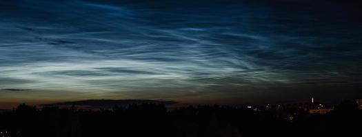 nuvole mesosferiche nottilucenti nel cielo notturno. fenomeno atmosferico raro sulla città. foto