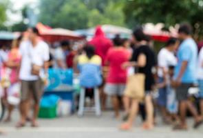 le persone sfocate stanno e camminano nel mercato. foto