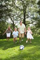 famiglia che gioca a calcio in giardino foto