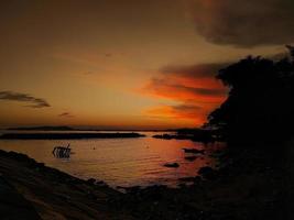 bella silhouette al tramonto sulla spiaggia foto