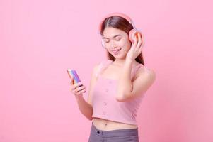 belle ragazze asiatiche ascoltano musica online tramite la connessione Internet del telefono cellulare e ballano allegramente foto