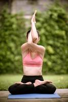 la meditazione e lo stretching delle donne asiatiche rilassano i muscoli facendo yoga in giardino foto