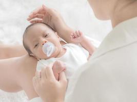 una bella donna asiatica mette il suo neonato sul suo corpo foto