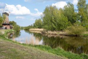 paesaggio con fiume e mulino a vento foto