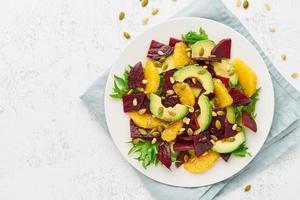 insalata vegana con cagliata di barbabietola, avocado, arancia, feta, ricotta e semi di zucca, cheto foto