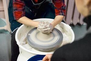 donna che fa ceramica sulla ruota, primo piano delle mani. concetto per donna in freelance foto