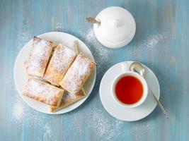 deliziosi rotoli di pasta sfoglia lussureggiante senza lievito. colazione con una tazza di tè foto