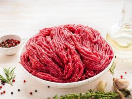 carne macinata di manzo, carne macinata con ingredienti per la cottura su blu scuro foto