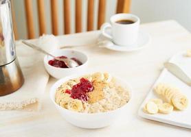 farina d'avena, grande ciotola di gustoso porridge sano per colazione, pasto mattutino foto