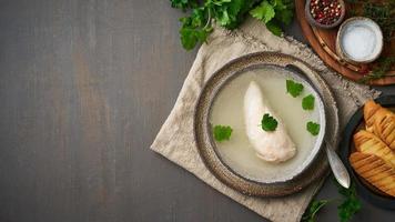 brodo di pollo con filetto di pollo, prezzemolo e pane tostato foto