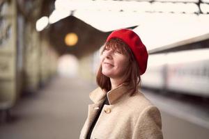 primo piano ritratto di bella donna, in attesa del treno sulla stazione ferroviaria. la ragazza viaggia leggera. foto