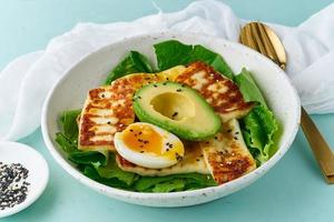 dieta cheto-chetogenica uova sode con avocado e lattuga su sfondo pastello primo piano foto