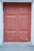 vecchia porta rossa incrinata sulla parte anteriore della casa foto