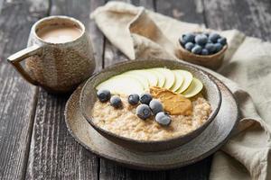 farina d'avena, porridge sano in una grande ciotola con frutta e bacche per colazione foto